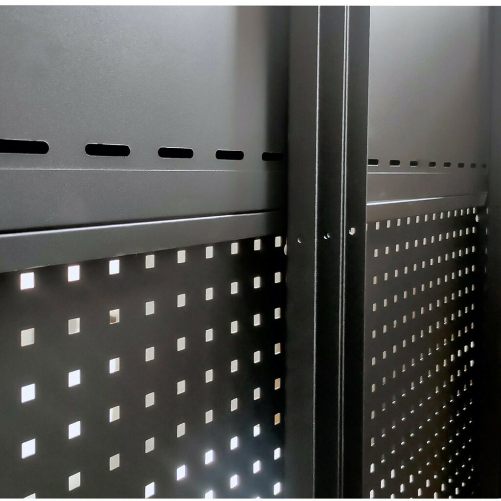 Närbild av en svart metallkonstruktion med perforerade paneler med fyrkantiga hål och vertikala stödbalkar, sannolikt en del av en industriell hylla eller ett förvaringsställ.