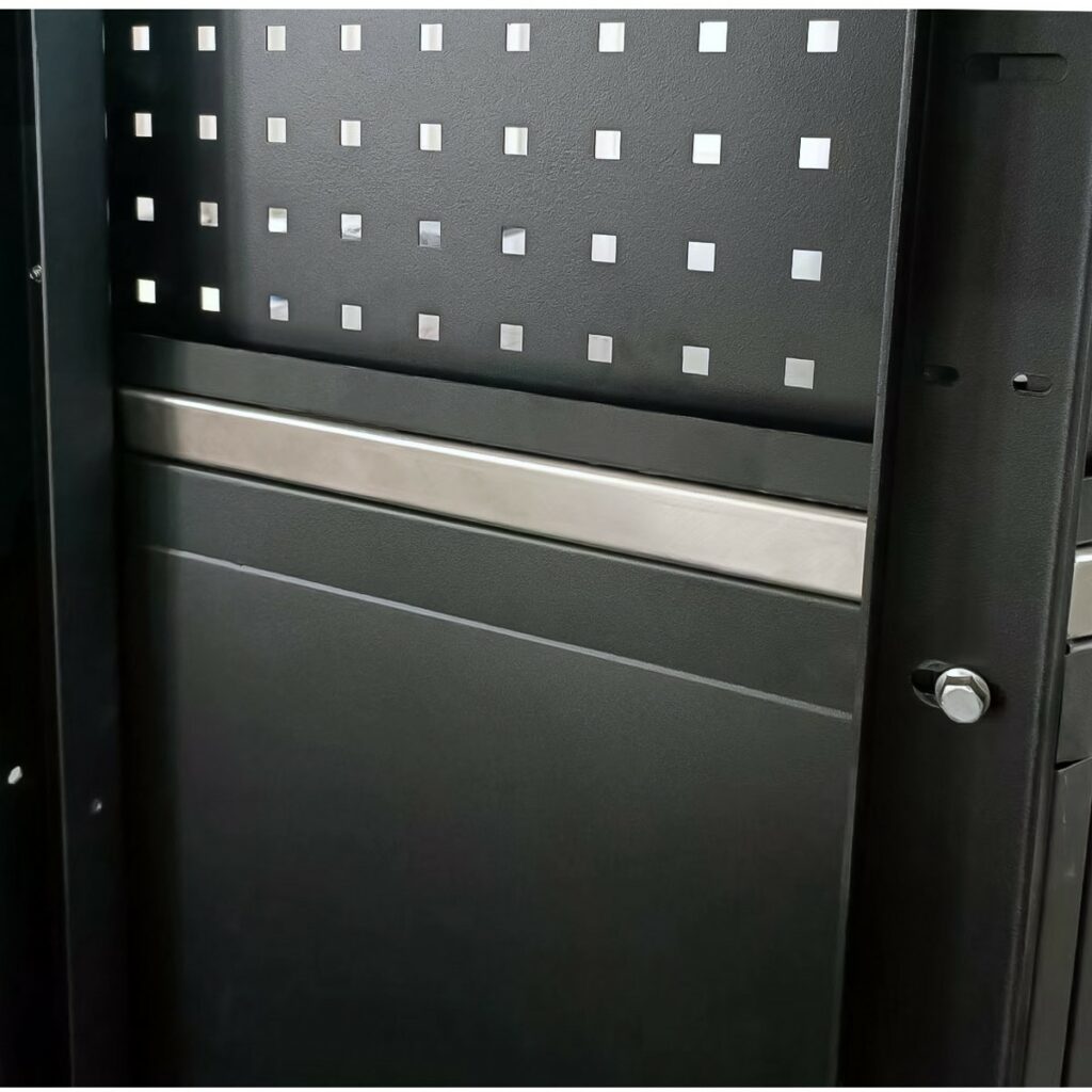 Närbild av ett svart metallskåp med ett rutmönster av små kvadratiska hål på dörren och en horisontell metallremsa nära mitten.