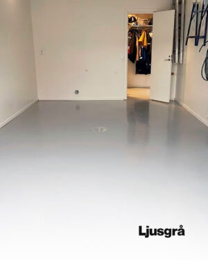 Ett rent, tomt garage har ett jämnt Epoxigolv-paketgolv i ljusgrått. En öppen dörr längst bort avslöjar en hall med upphängda ytterkläder. I det nedre högra hörnet står det ”Ljusgrå”.